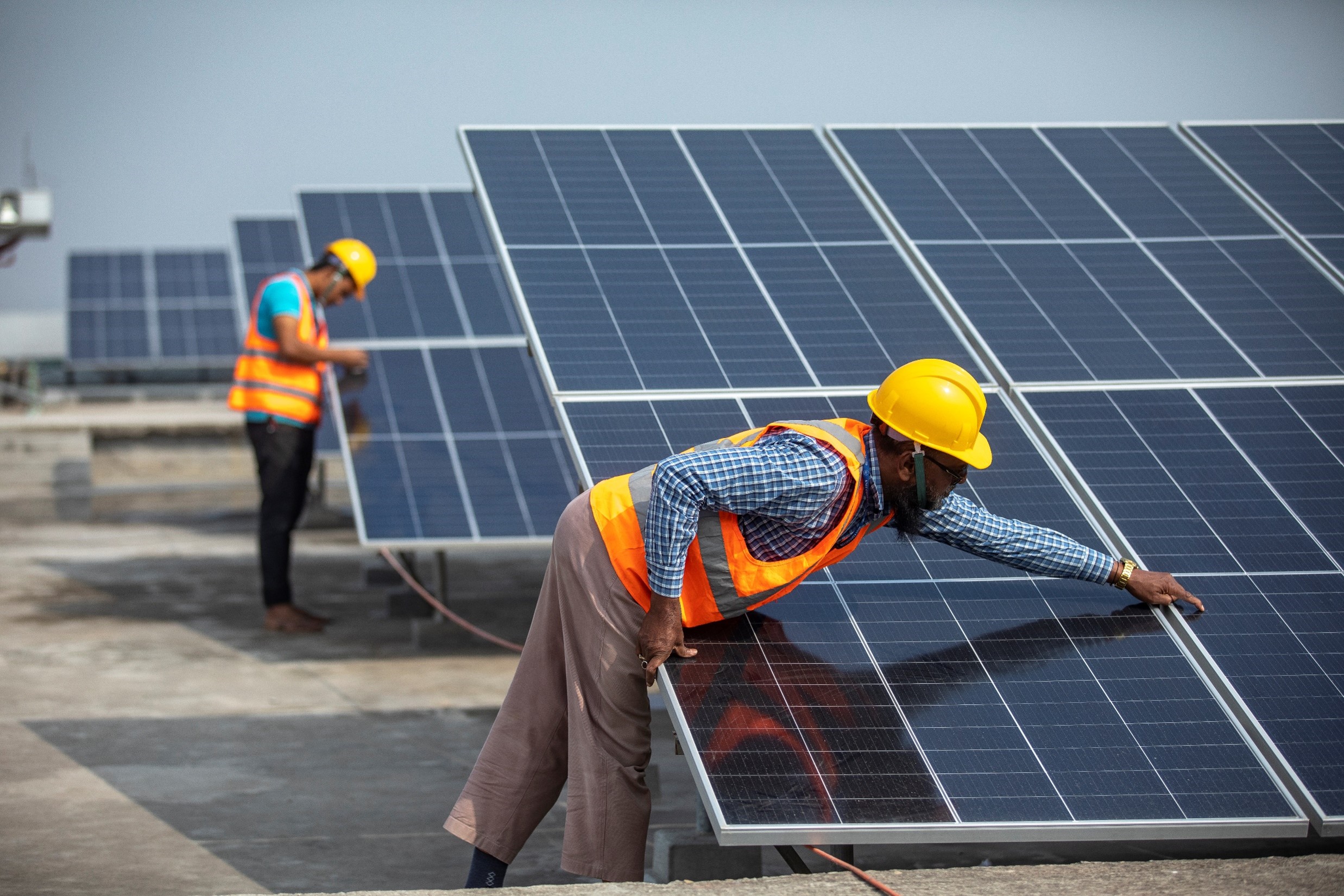 Workers installing solar panels on rooftop of Knit Concern Limited